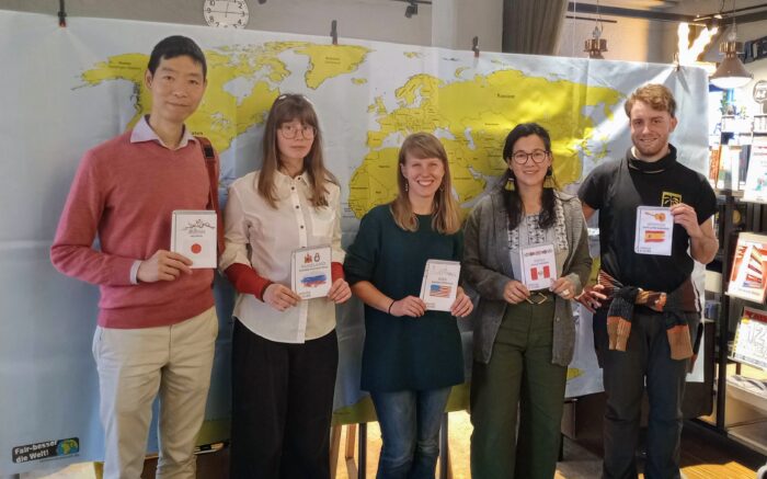 Unsere "lebenden Bücher" stehen vor einer Weltkarte, es sind Menschen aus Japan, Russland, den USA, Peru und Spanien.