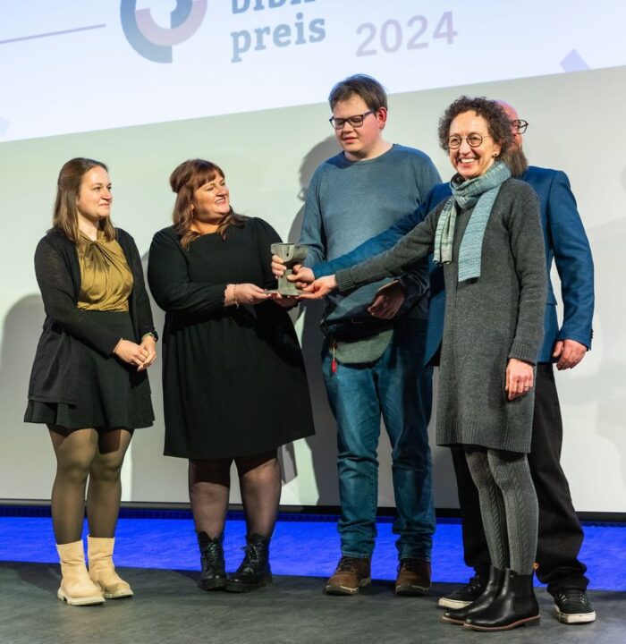 Vertreterinnen der Stadtbücherei und Simon Schreiner bei der symbolischen "Gleisübergabe"