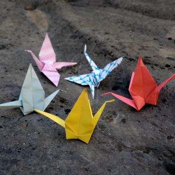 Origami-Kraniche liegen auf einem Felsen