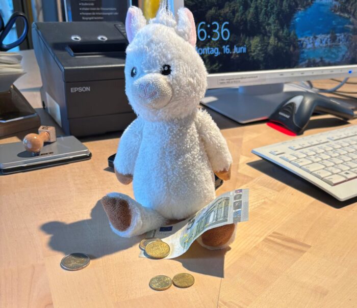 Finchen das Plüsch-Alpaka zählt Geld.