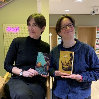 Zu sehen sind Autorin Gaea Schoeters und ihre Übersetzerin Lisa Mensing, die die beiden Bücher "Das Geschenk" und "Trophäe" halten.