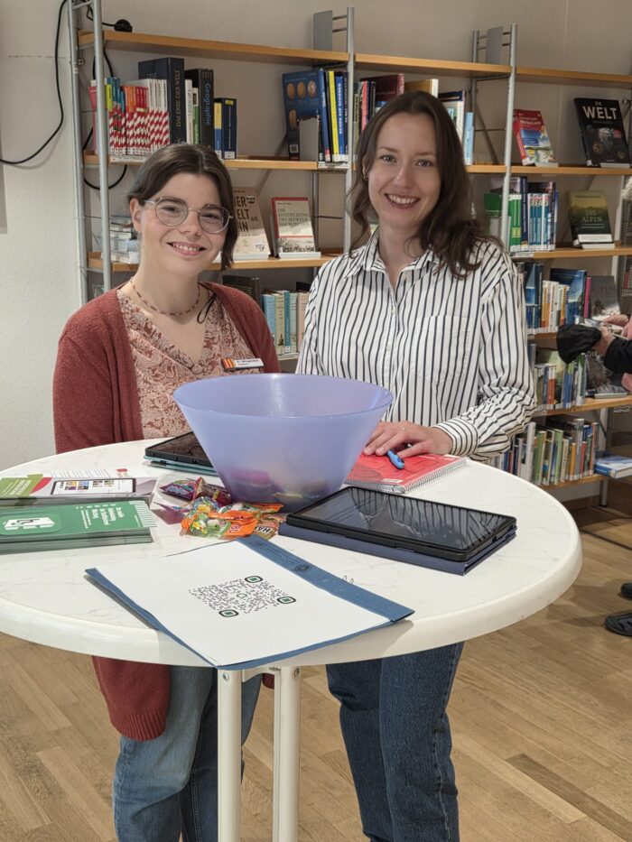 Zu sehen sind die Praktikantinnen Laura und Julia an einem Stehtisch im Falkenhaus.